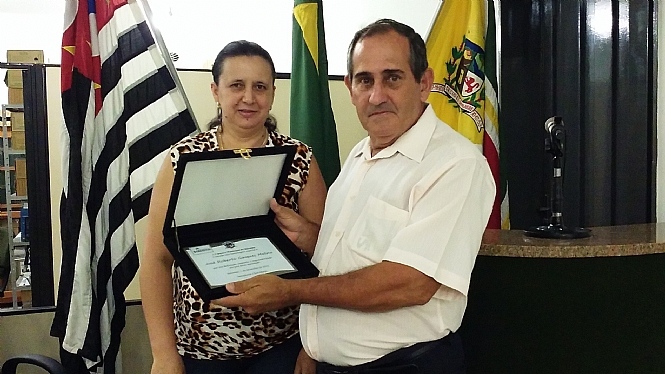 Molina recebendo a placa de homenagem da presidente Rosimar
